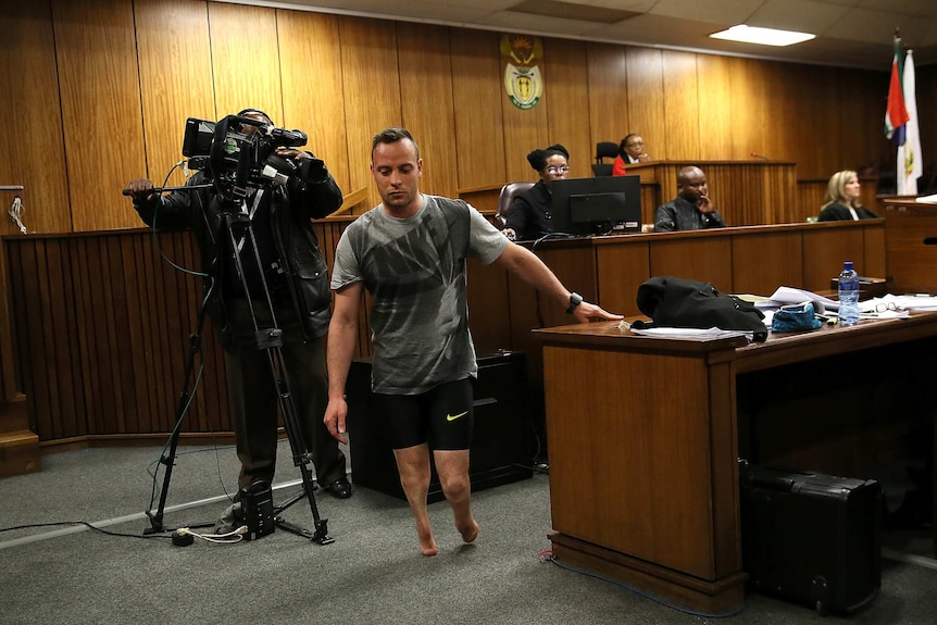 Oscar Pistorius walks in the courtroom without his prosthetic legs.