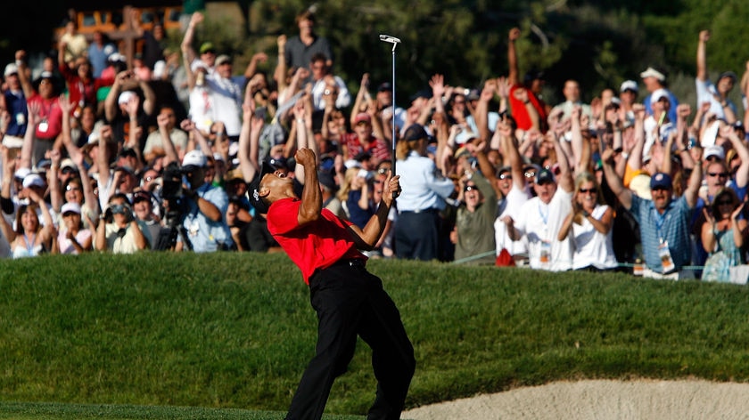 Tiger Woods reacts to his birdie putt on the 18th green