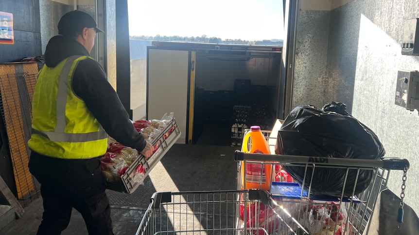 AN OzHarvest driver loading the van with supermarket donations.