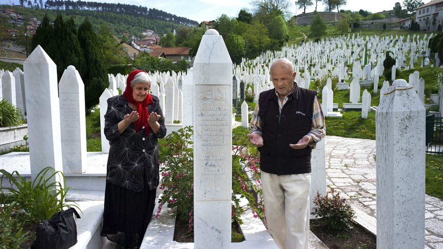 Two Bosnian-Muslims at a grave site.