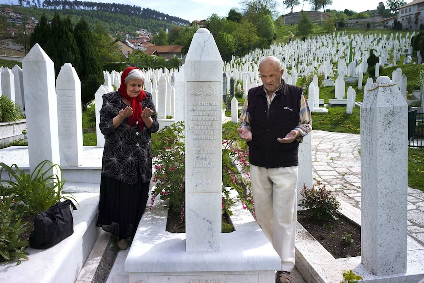 Two Bosnian-Muslims at a grave site.