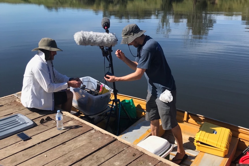 Two men in a tinny with AV gear.