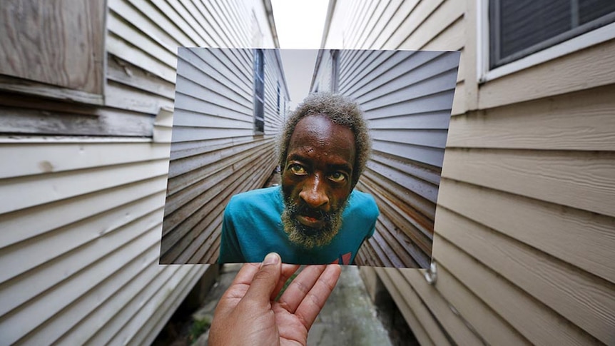 Carlos Barria holds his photo