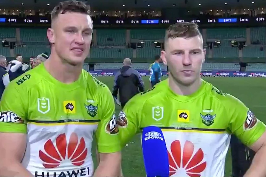 Two men stand next to each other after a football match