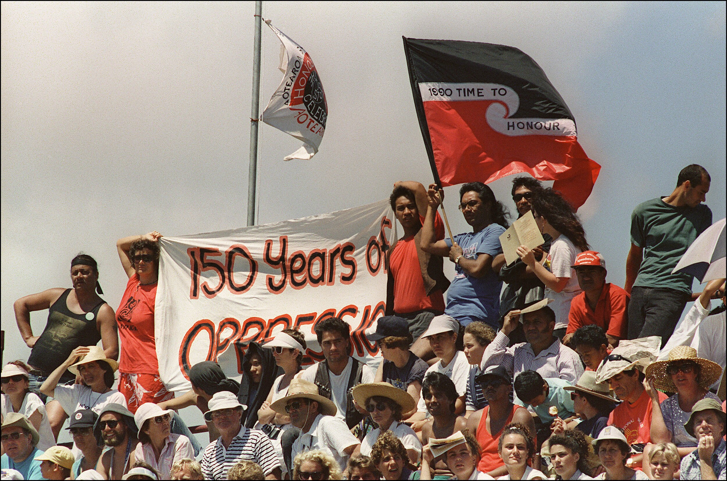 Protesters hold a banner that says '150 years of oppression'