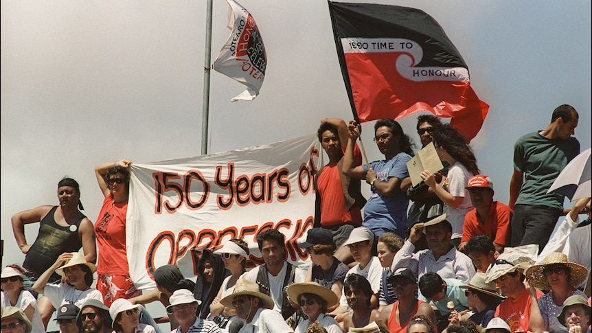 Protesters hold a banner that says '150 years of oppression'