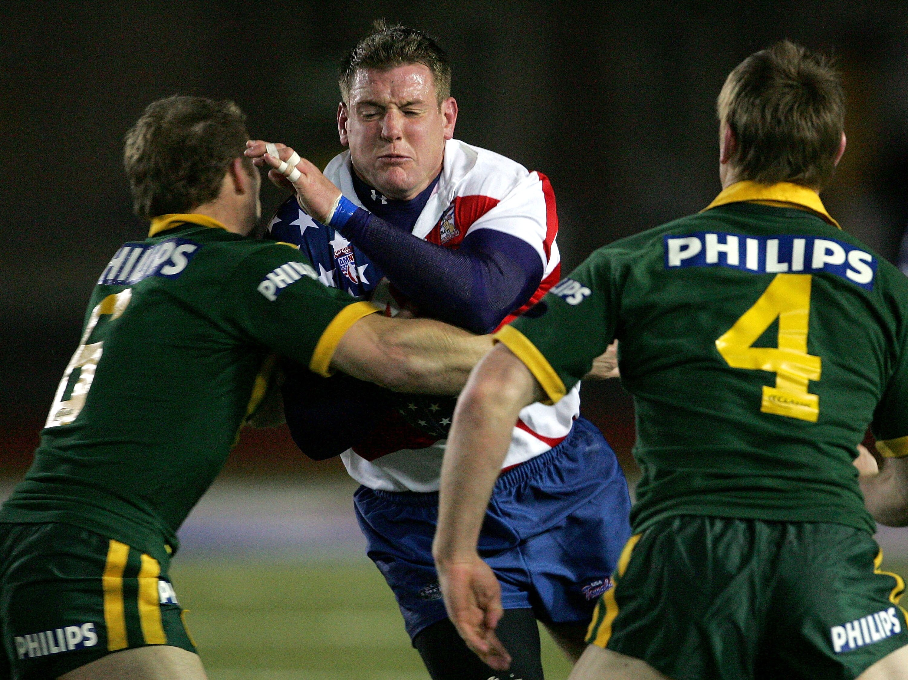 A man runs the ball during a rugby league match