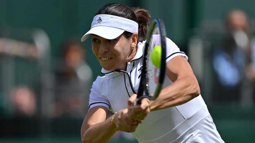 Australia's Ajla Tomljanovic grimaces as she leans forward to hit a double-handed backhand  at Wimbledon.