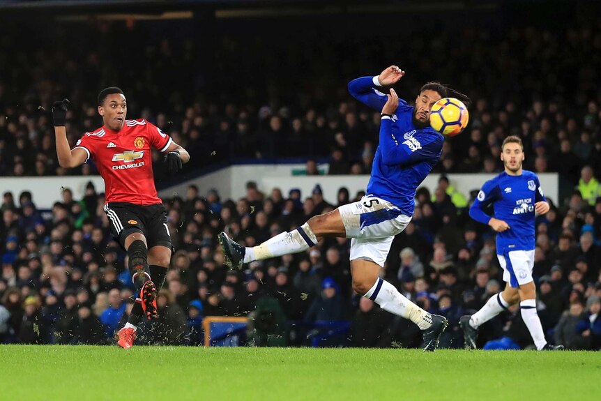 Manchester United's Anthony Martial (L), scores against Everton at Goodison Park on January 1, 2018.
