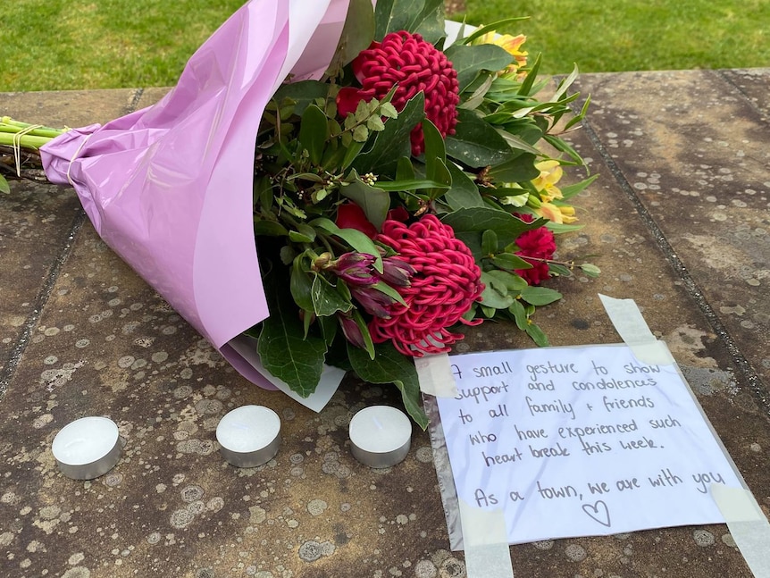 A bunch of flowers and a note saying the community is thinking of the victims.