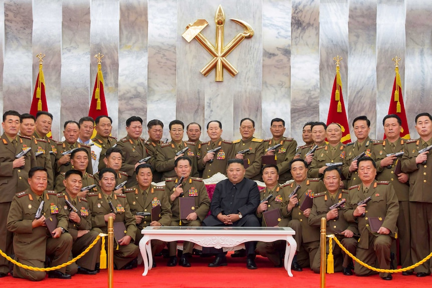 A photo of Kim Jong-un surrounded by soldiers brandishing hand guns