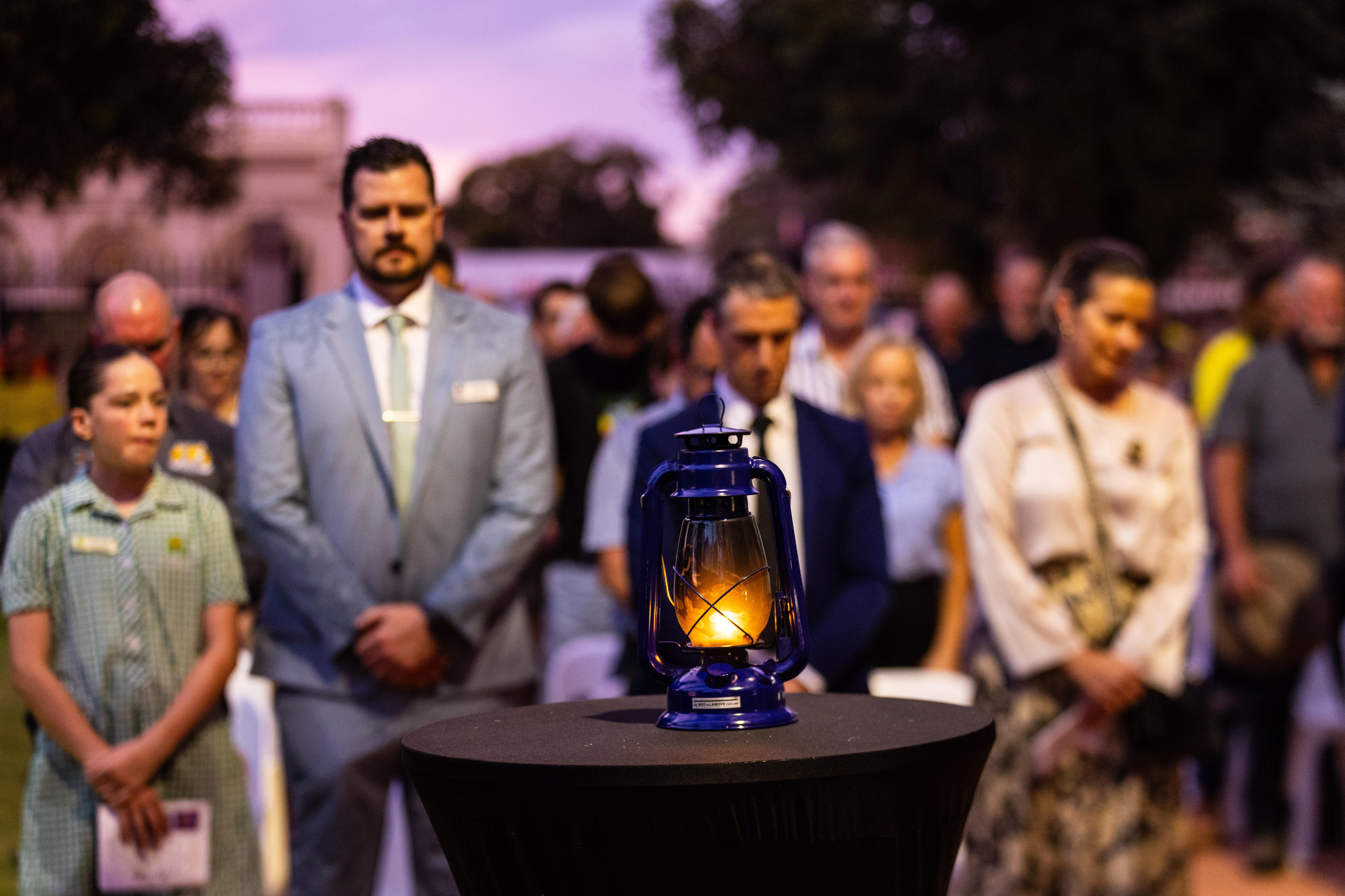 Una llama arde en una linterna en un servicio conmemorativo.  