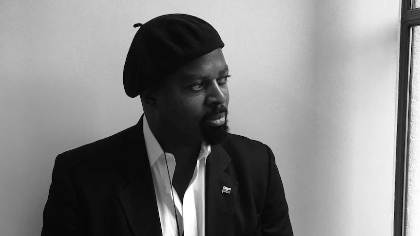 Man in beret standing against a wall for author portrait