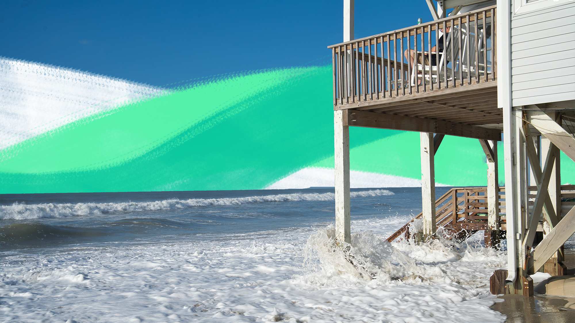 Waves crash underneath a beach-front house for a story about climate risks when buying property.