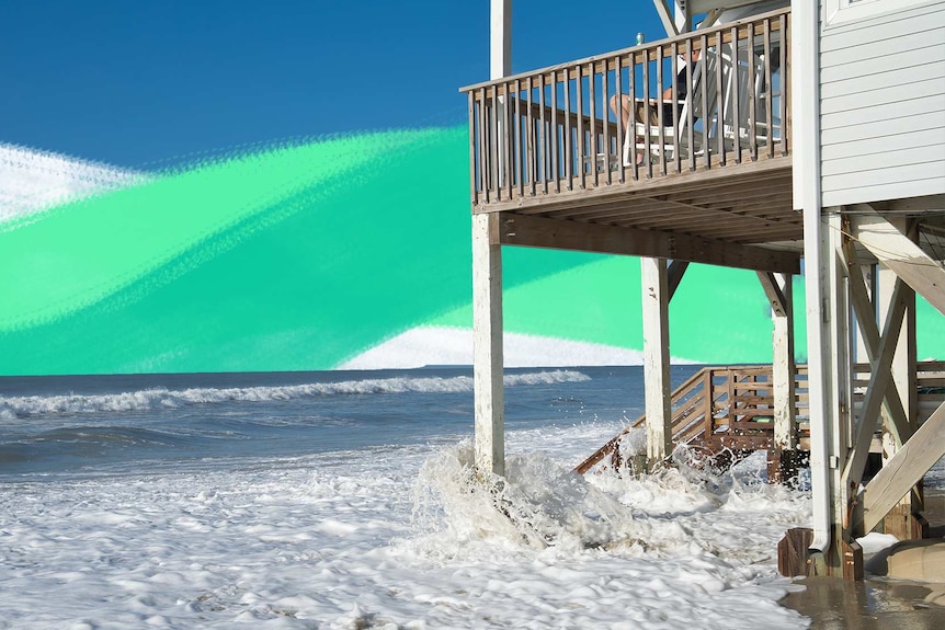Waves crash underneath a beach-front house.