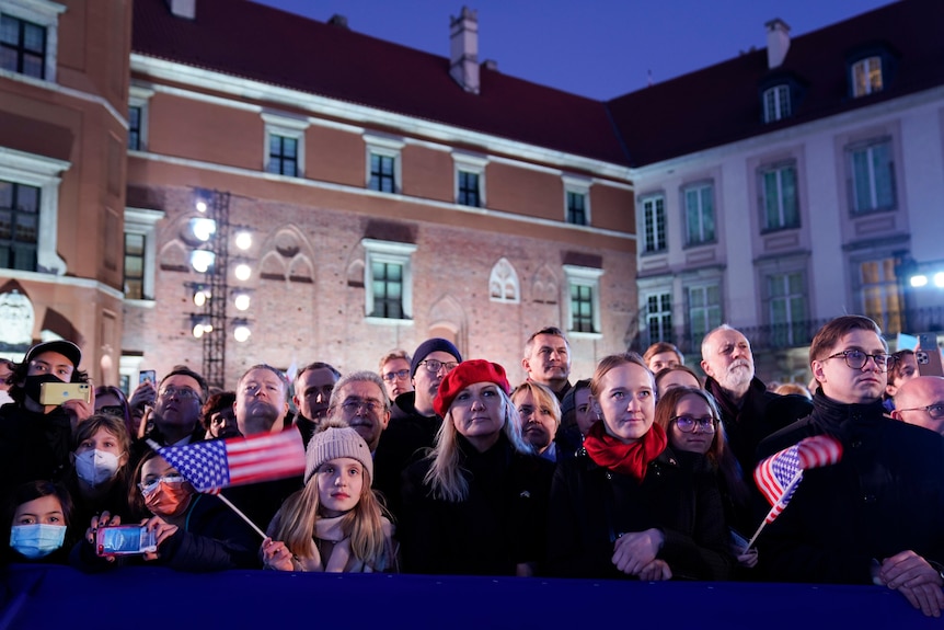 People listen as President Joe Biden delivers a speech about the Russian invasion of Ukraine.