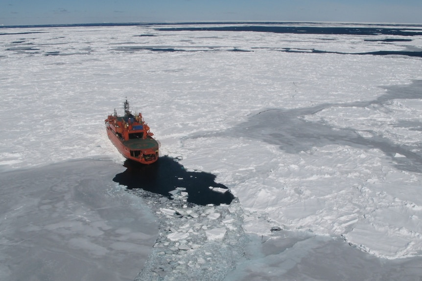 Icebreaker ship moving through Antarctic sea ice.