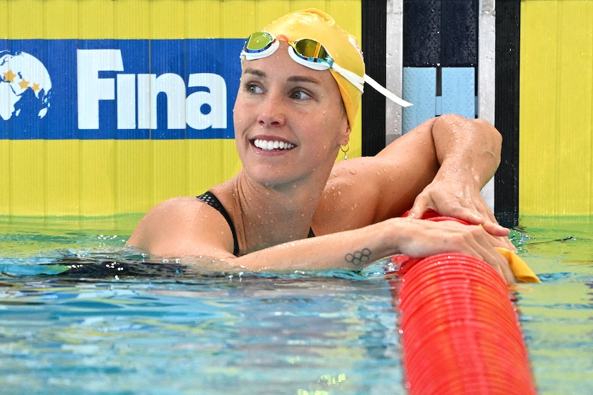 An Australian female swimmer smiles after winning gold at the world short course championships.