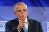 Scott Morrison points while delivering a speech at a lecturn