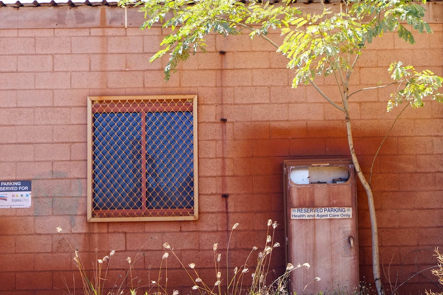 A building with large patches of red dust on it.