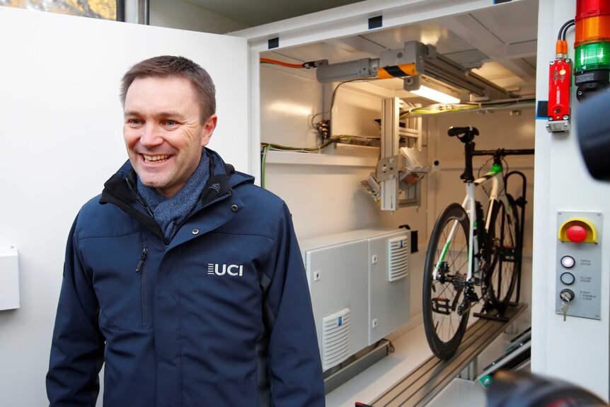 David Lappartient, President of the International Cycling Union (UCI) poses next to the x-ray machine
