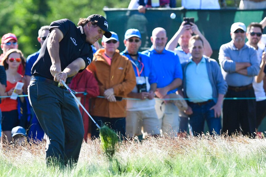 Phil Mickelson shoots from the fescue on the twelfth hole during the first round of the U.S. Open.