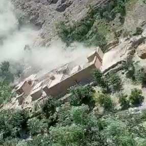 Smoke rises from an explosion in a mud brick home.