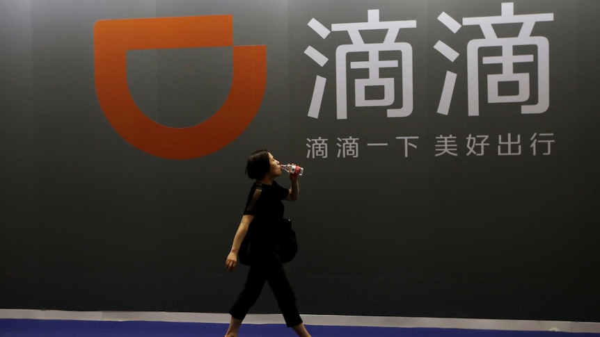 A woman walks past DiDi Chuxing's booth.