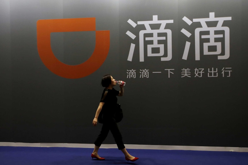 A woman walks past DiDi Chuxing's booth.