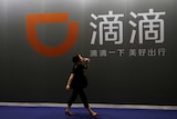 A woman walks past DiDi Chuxing's booth.