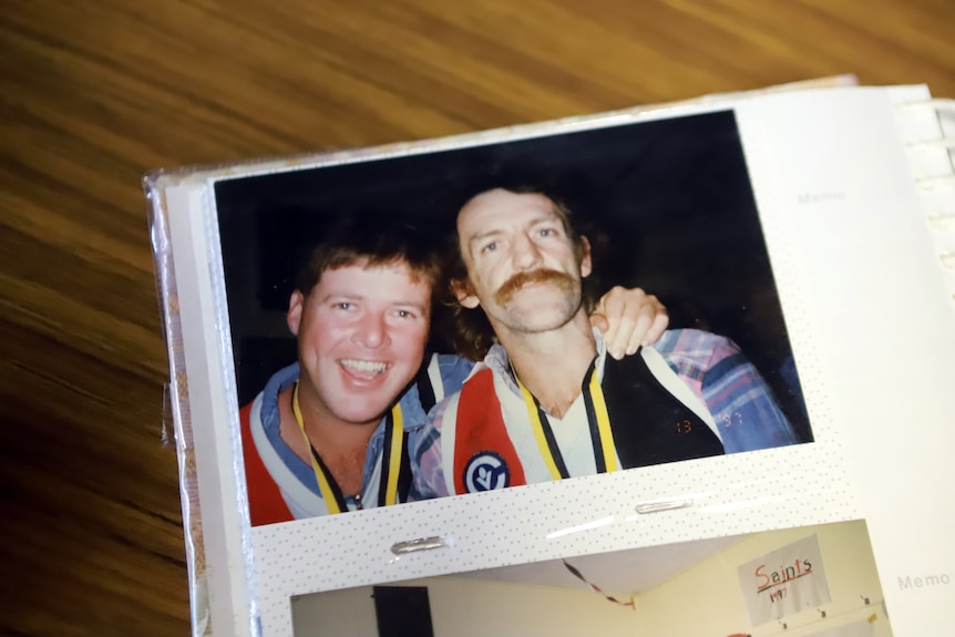 A photo of two men smiling in a photo book