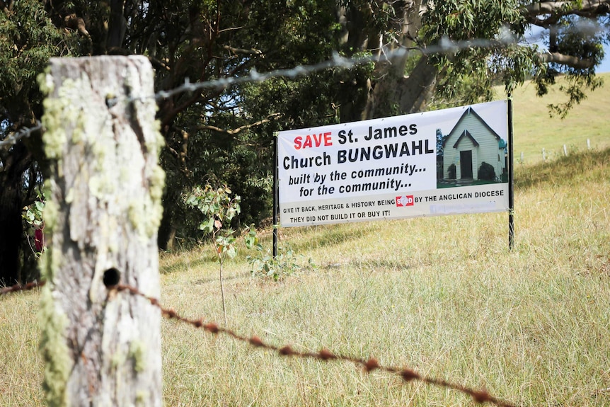 A Save St James Church sign stands in a dry field