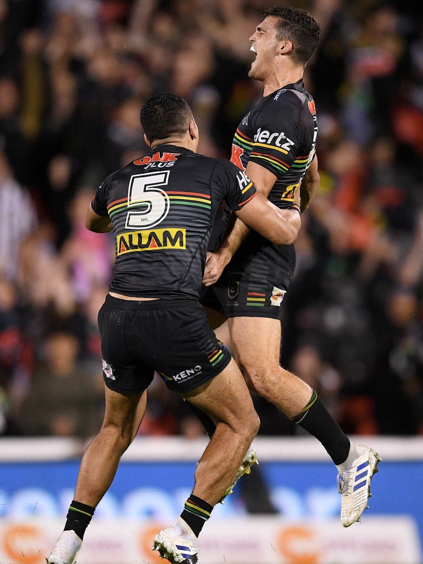 Nathan Cleary screams out in celebration as he jumps in the air, while Dallin Watene-Zelezniak runs to hug him.