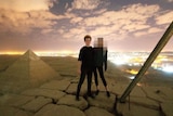 a man and a woman stand on top of what appears to be a pyramid with the woman's face blurred
