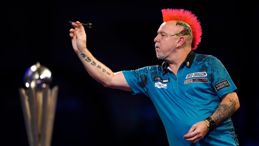 Man with mohawk plays darts