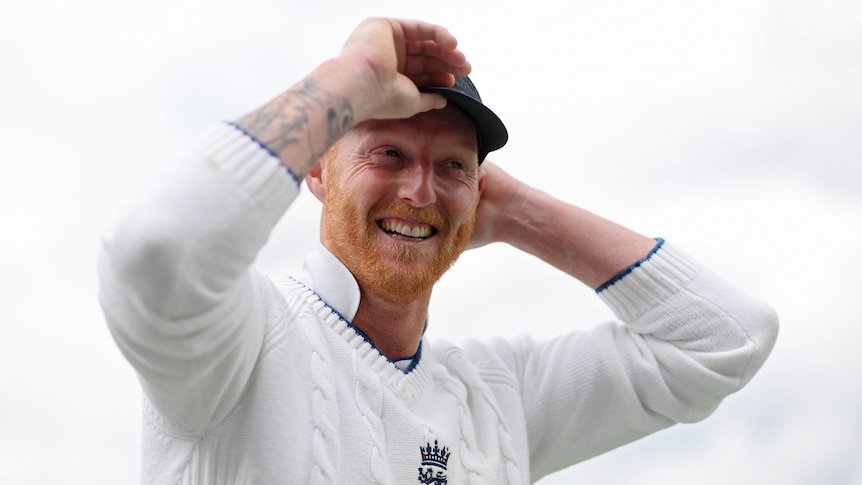 Ben Stokes smiles and adjusts his cap