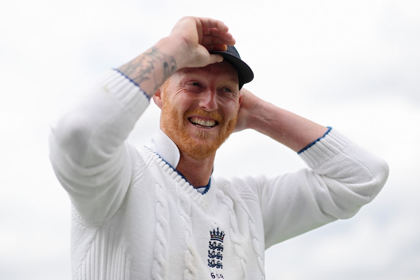 Ben Stokes smiles and adjusts his cap