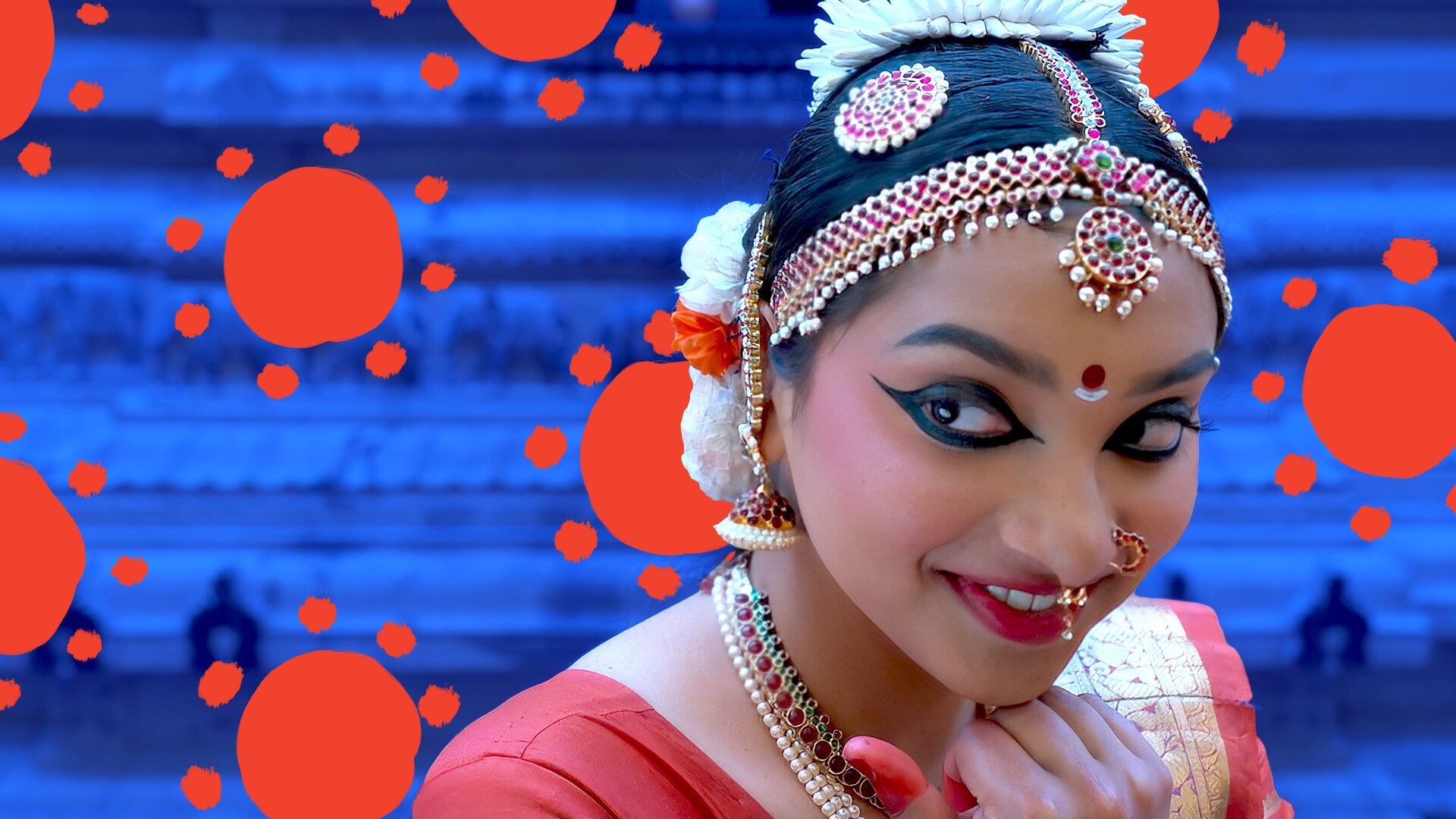 A woman in traditional Indian dance costume smiles.