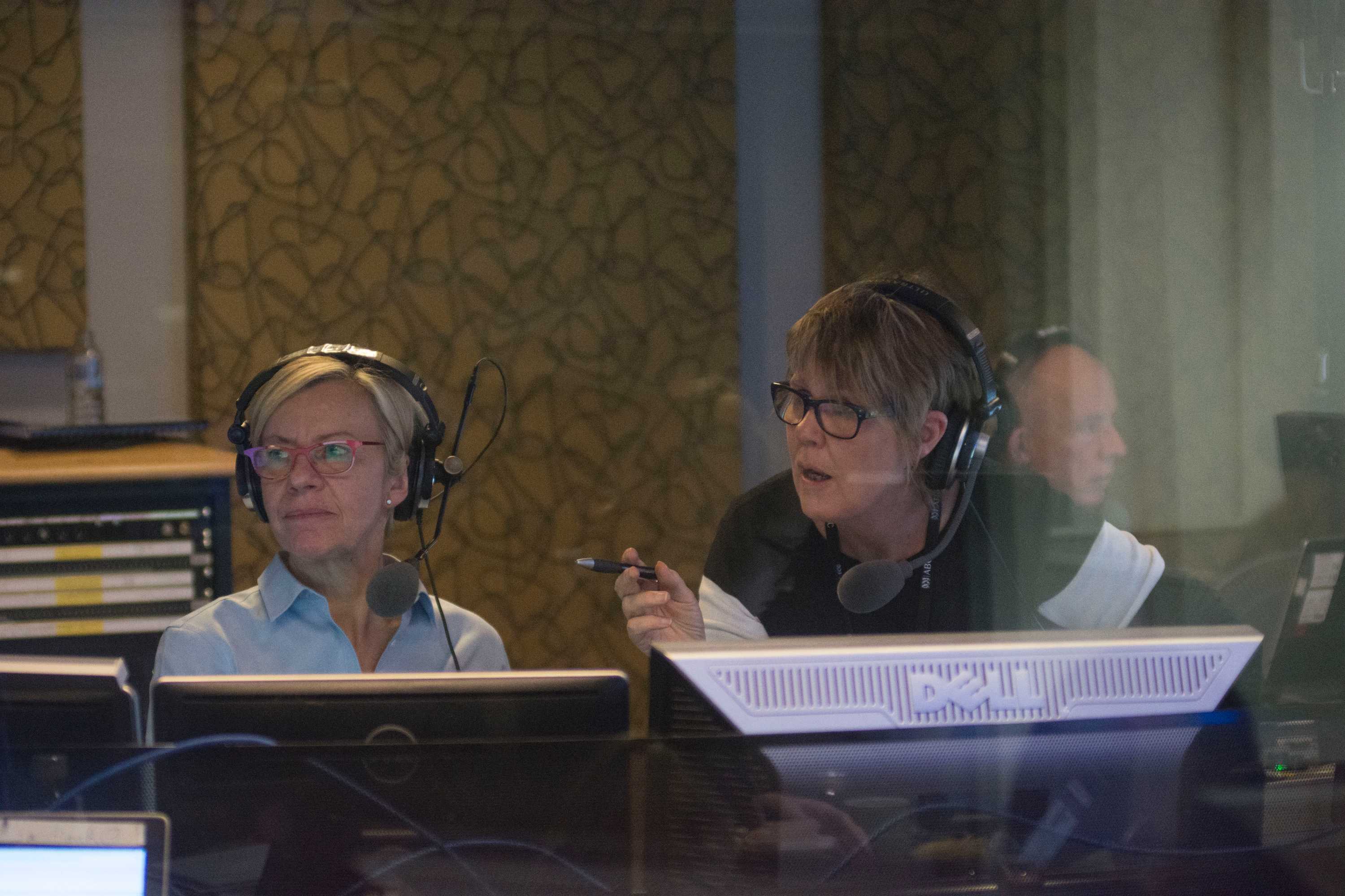 Black and white photo of Aloisi and Kelly on air in radio studio.