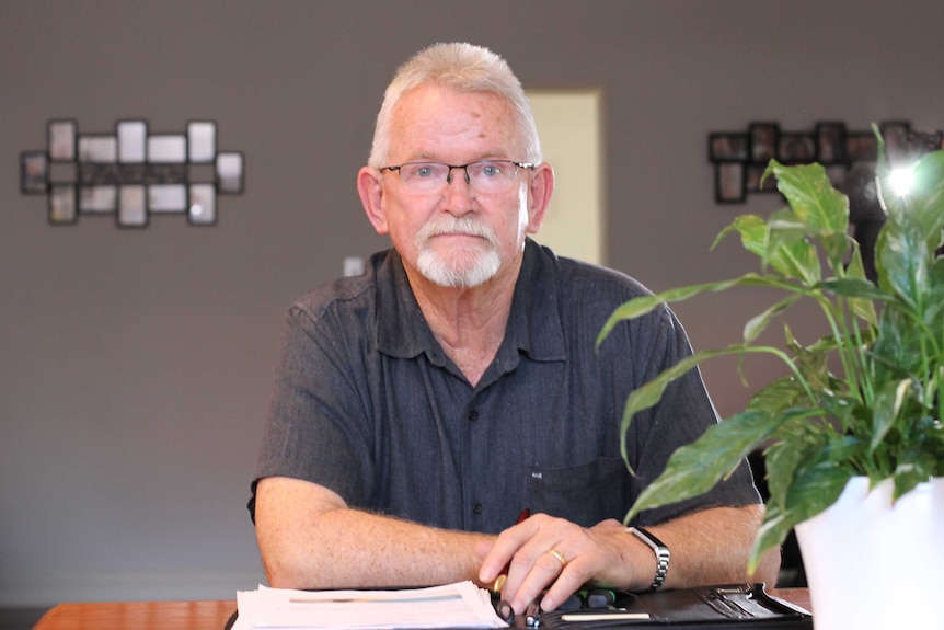 Max Green sitting at his desk with file of documents in front of him