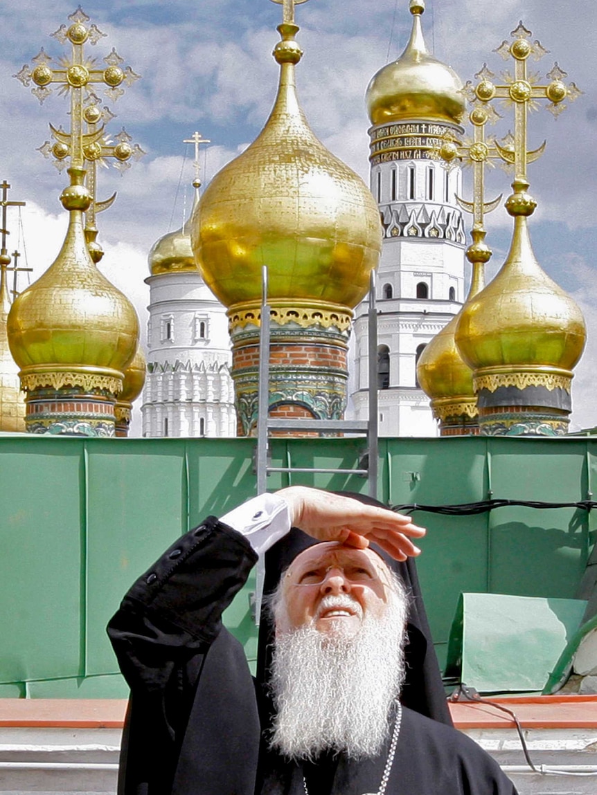 Patriarch Bartholomew I squints as he looks up into the sky