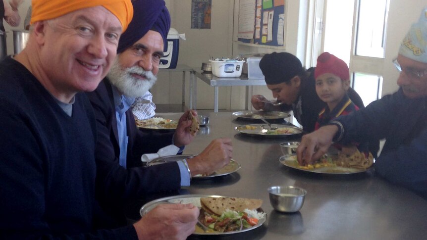 John McGlue shares a meal at the Sikh temple.