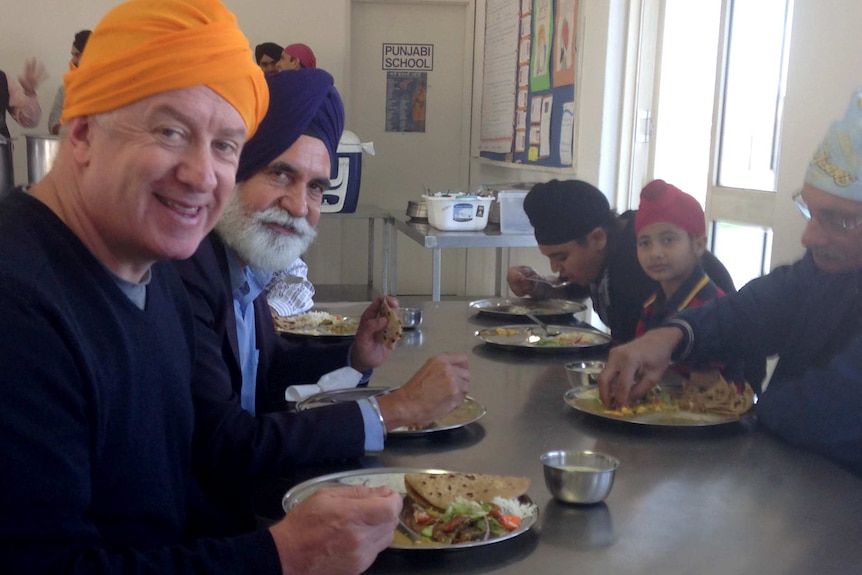 John McGlue shares a meal at the Sikh temple.