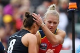 Erin Phillips hugging a Carlton player after being taken off Adelaide Oval after sustaining a knee injury.