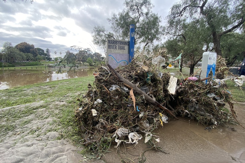 A pile of garbage in front of the river.