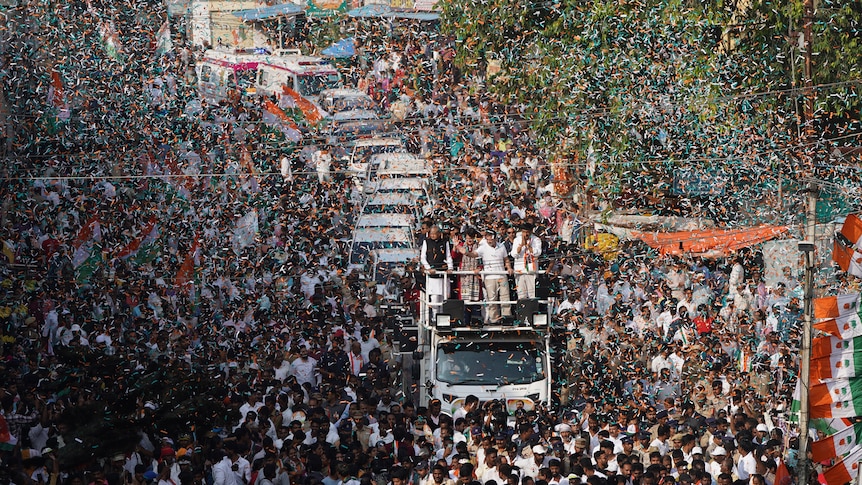 Rahul and Priyanka Gandhi greet a sea of supporters from the top of a truck in the southern city of Hyderabad, November 2023.