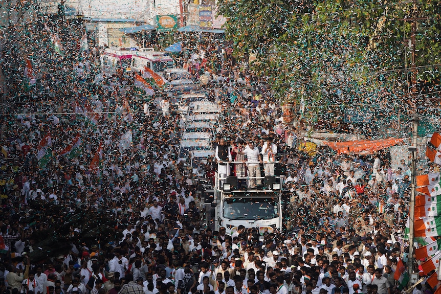 Rahul and Priyanka Gandhi greet a sea of supporters from the top of a truck in the southern city of Hyderabad, November 2023.