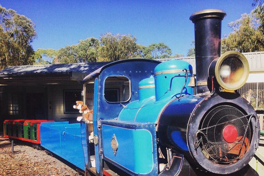 A blue and red train sits idle.