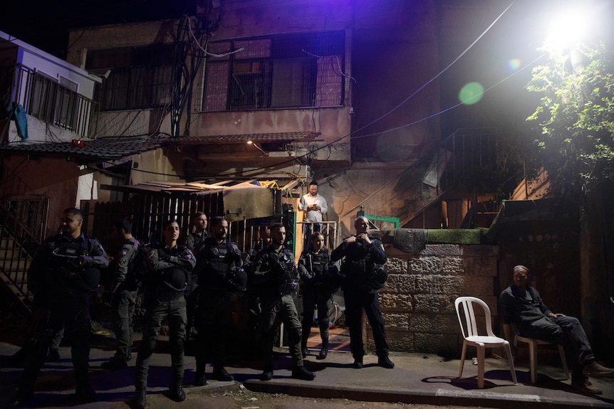 sraeli police stand guard in front of a Palestinian home occupied by settlers