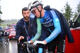 Ben O'Connor speaks to an official while on his bike